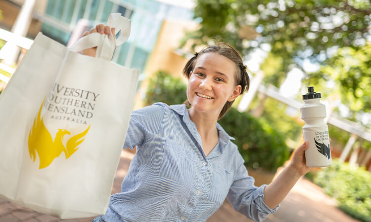 Young woman holding USQ bag and water bottle
