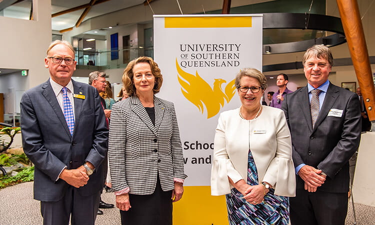 Four people standing together for law school launch