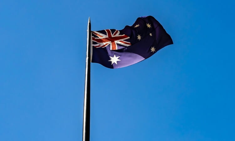 Australian flag waving against a clear blue sky.