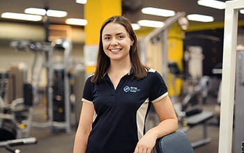 USQ student, Lucy, standing in a gym.